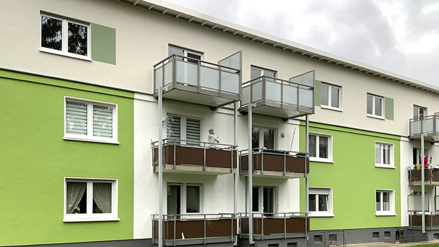 Mehrfamilienwohnhaus mit grün-weißer Fassade