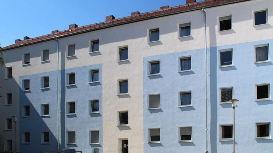 Mehrstöckiges Wohnhaus mit blau-weißer Fassade