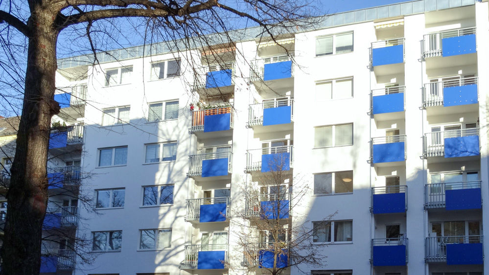 Mehrstöckiges Wohnhaus mit blauen Balkonblenden