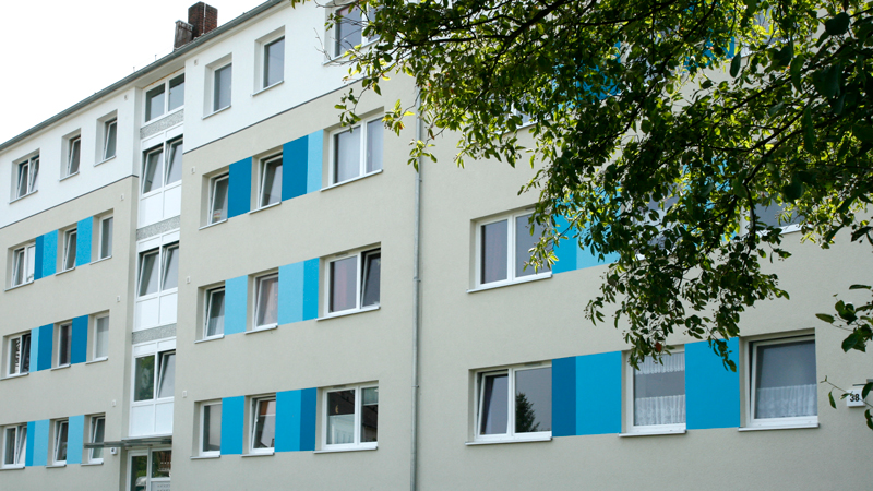 Wohnhaus mit grauer Fassade und blauen Akzentuierungen